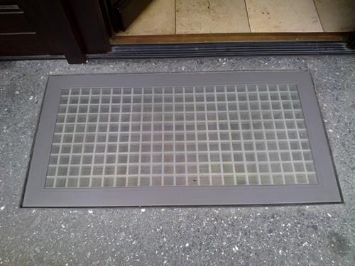 Eine Fußmatte liegt neben einer Tür auf dem Boden.