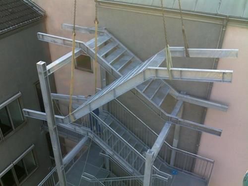 Vor einem Gebäude wird eine Metalltreppe gebaut