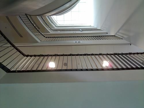 Blick nach oben auf eine Treppe mit einem Oberlicht in der Decke