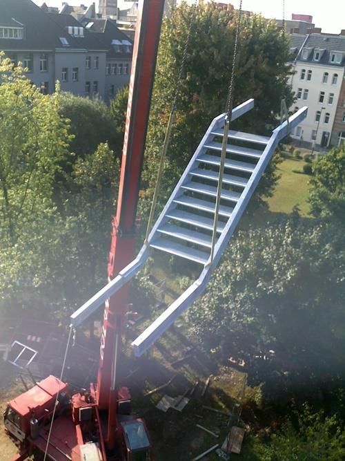 Eine große Treppe wird von einem Kran angehoben