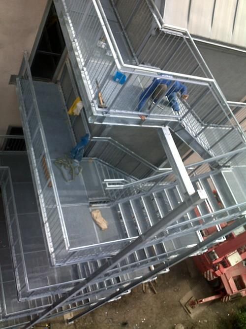 Ein Mann steht auf einer Metalltreppe.