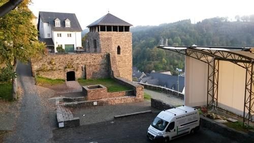Ein weißer Lieferwagen parkt vor einem Schloss.