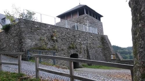 Ein großes Steingebäude mit einem Holzzaun davor.