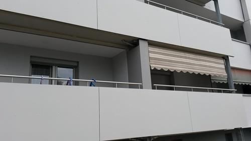 Ein Balkon mit einer gestreiften Markise