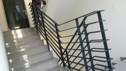 Eine Treppe mit einem Metallgeländer in einem Gebäude.