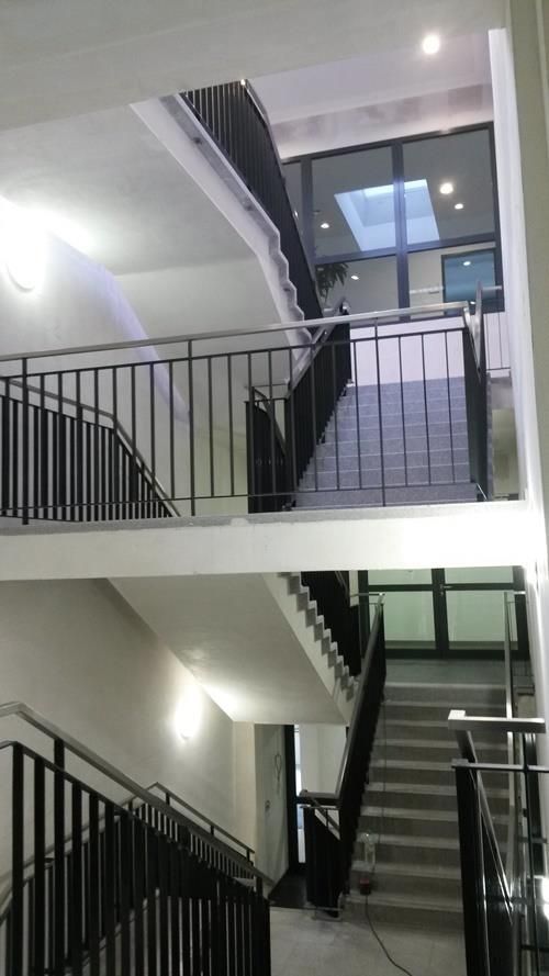 Eine Treppe mit Geländer und Balkon in einem Gebäude.