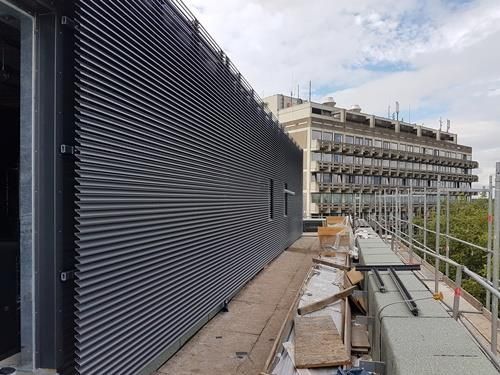 Ein großes im Bau befindliches Gebäude mit Gerüst an der Seite.