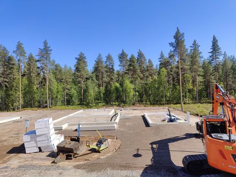 Oranssi Doosan-kaivinkone kaivaa rakennustyömaalla aurinkoisena päivänä.