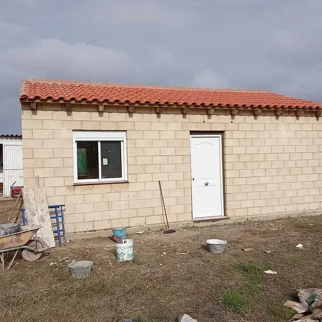 Una pequeña casa de ladrillo con techo de tejas rojas