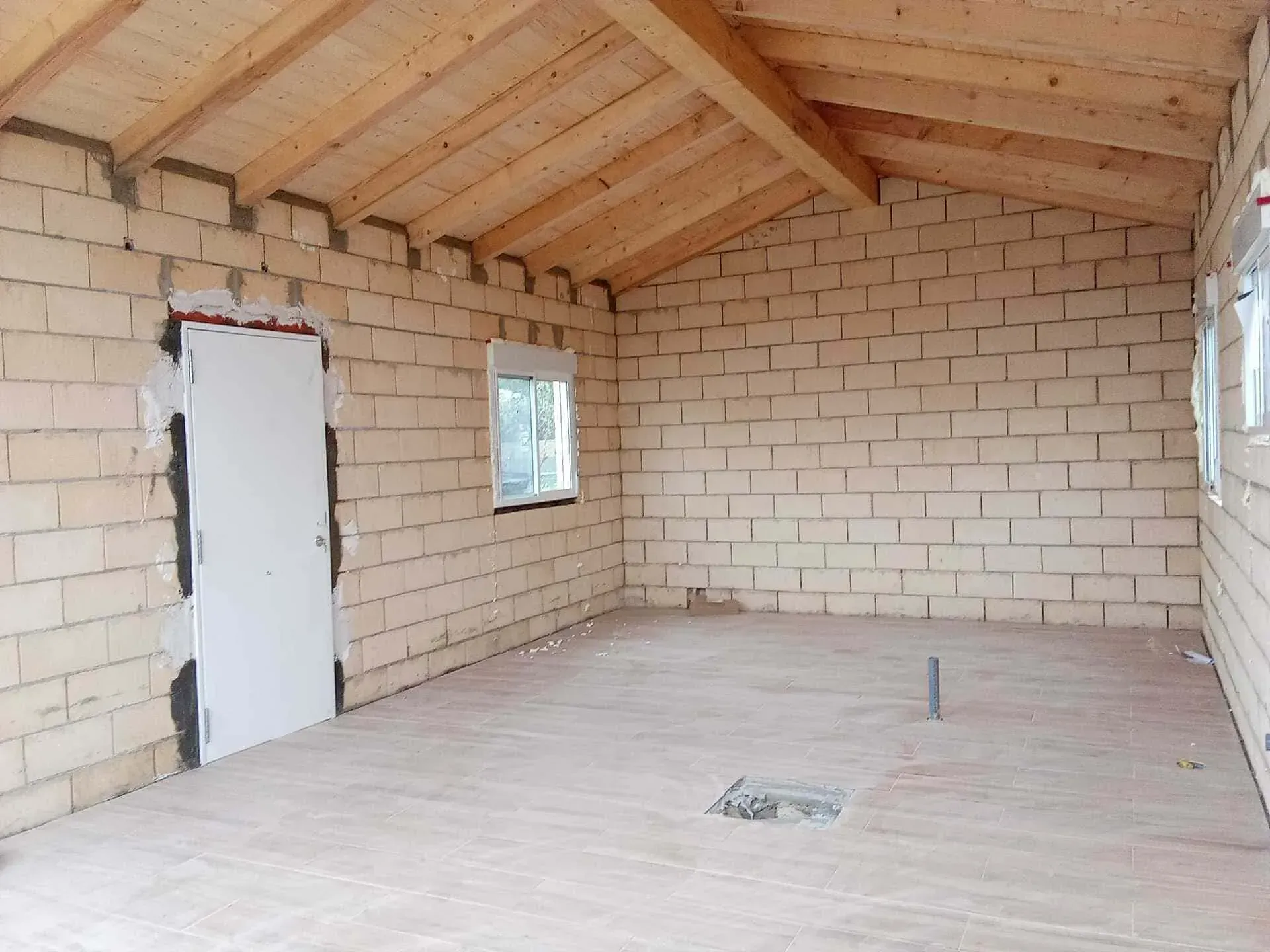 Una habitación vacía con paredes de ladrillo y techo de madera.