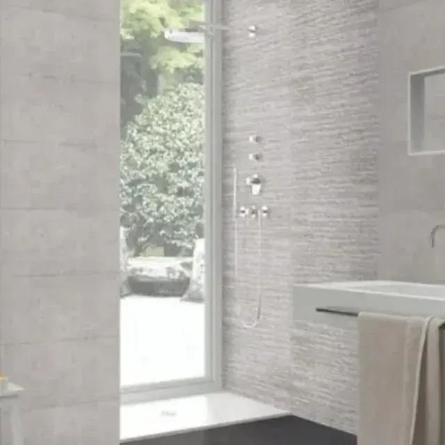 Un baño con lavabo, ducha y ventana.