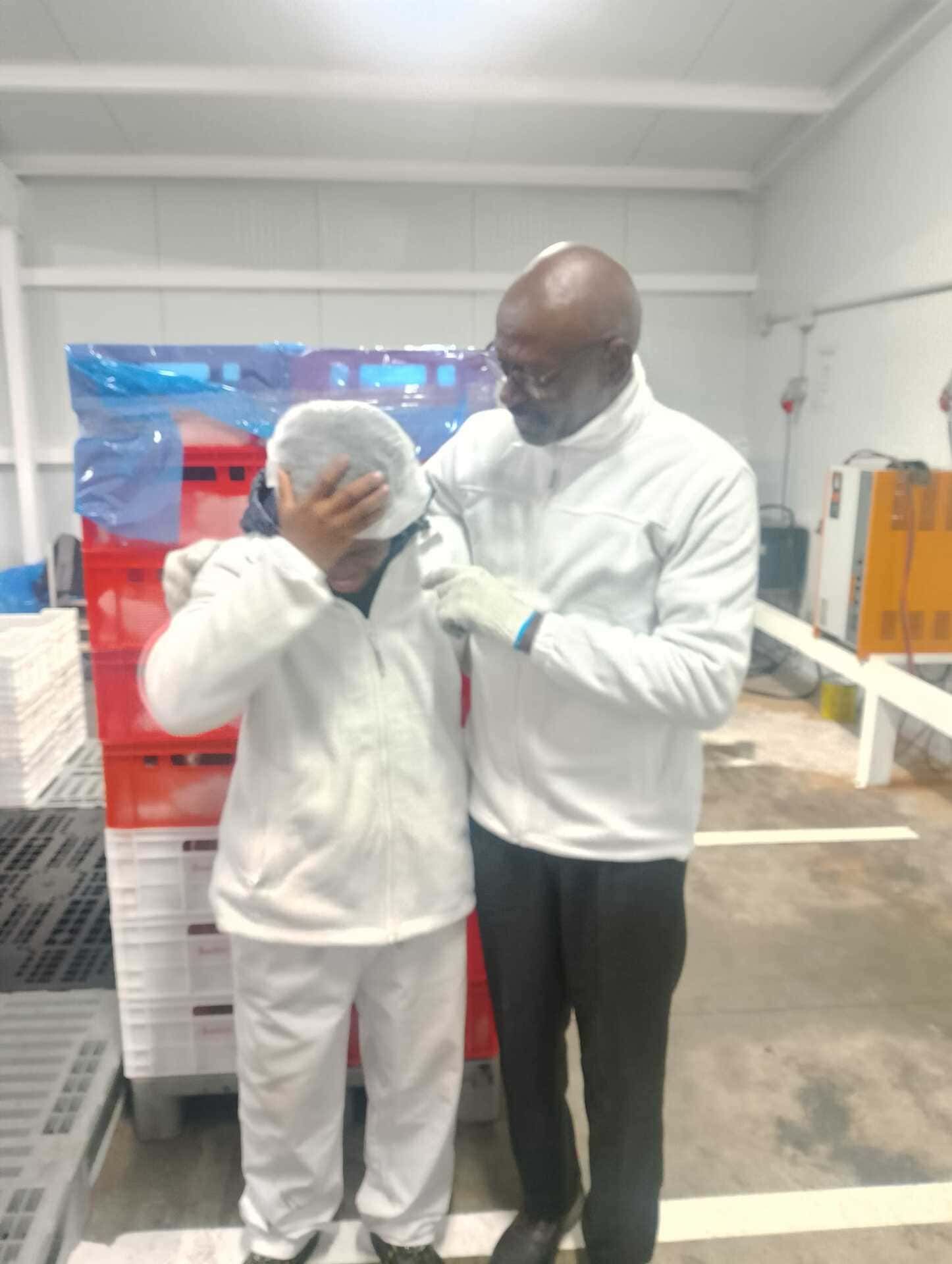 Dos hombres están parados uno al lado del otro en una habitación.