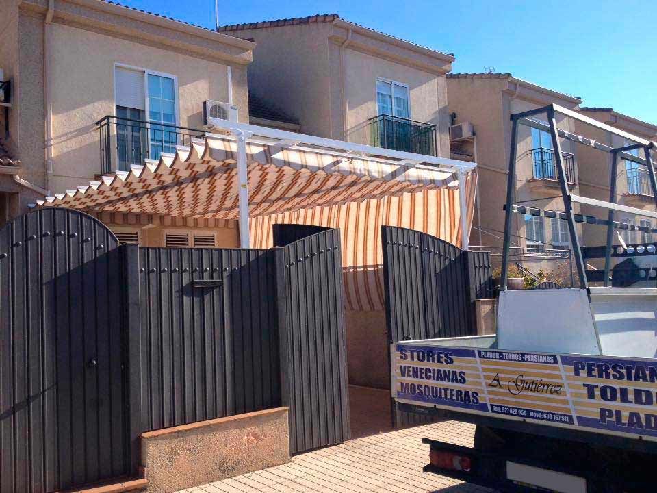 Un camión está estacionado frente a una casa con un toldo encima.