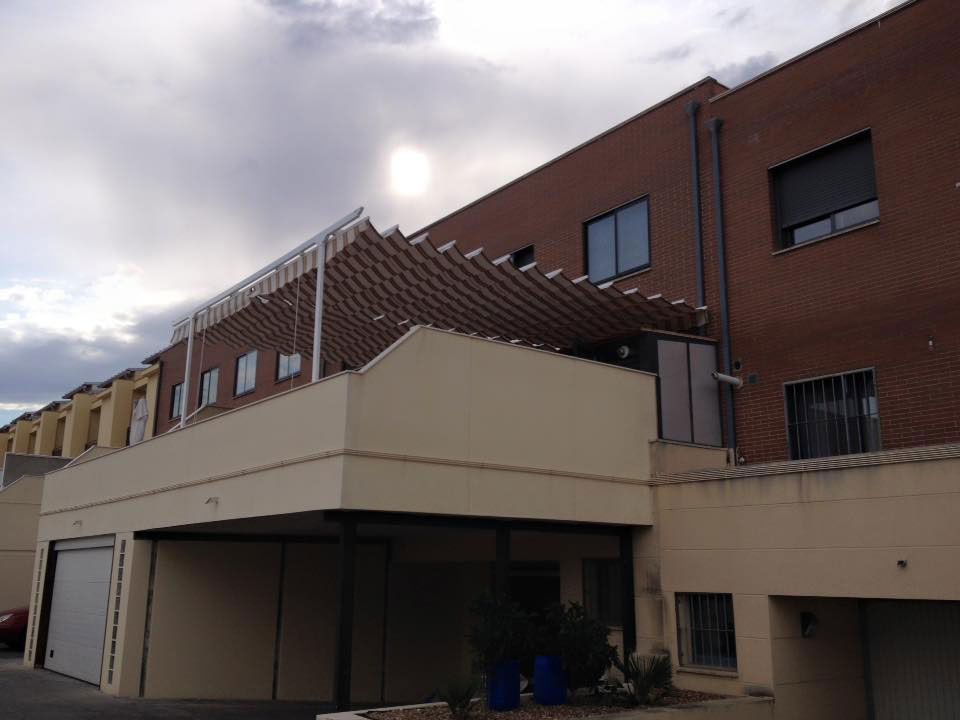 Un edificio de ladrillo con un toldo blanco encima.