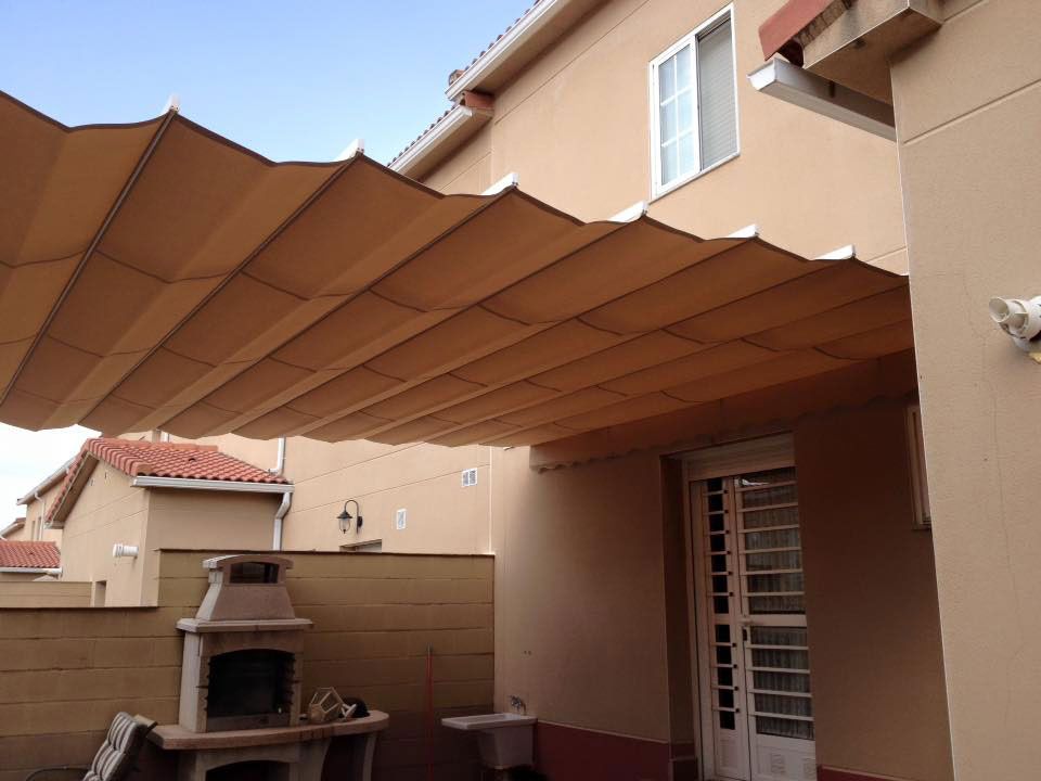 Una casa con un área de patio con un dosel encima.