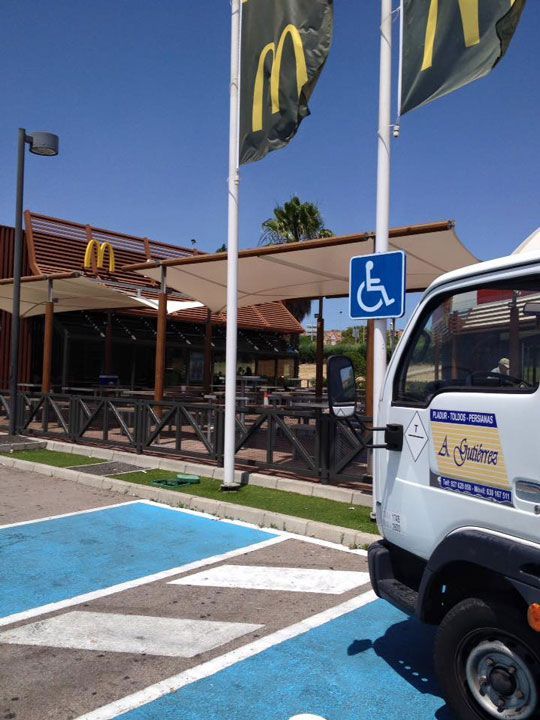 Un camión blanco está estacionado frente a un McDonald's.