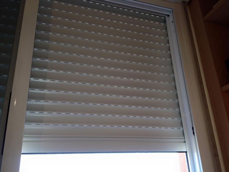 Una ventana con una persiana blanca