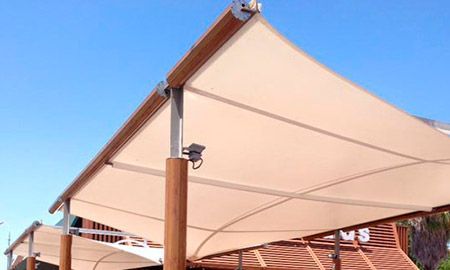 Una gran sombrilla está colocada encima de una estructura de madera.