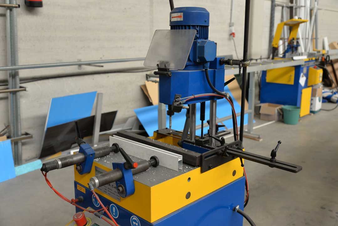 Una máquina azul y amarilla está en un almacén.