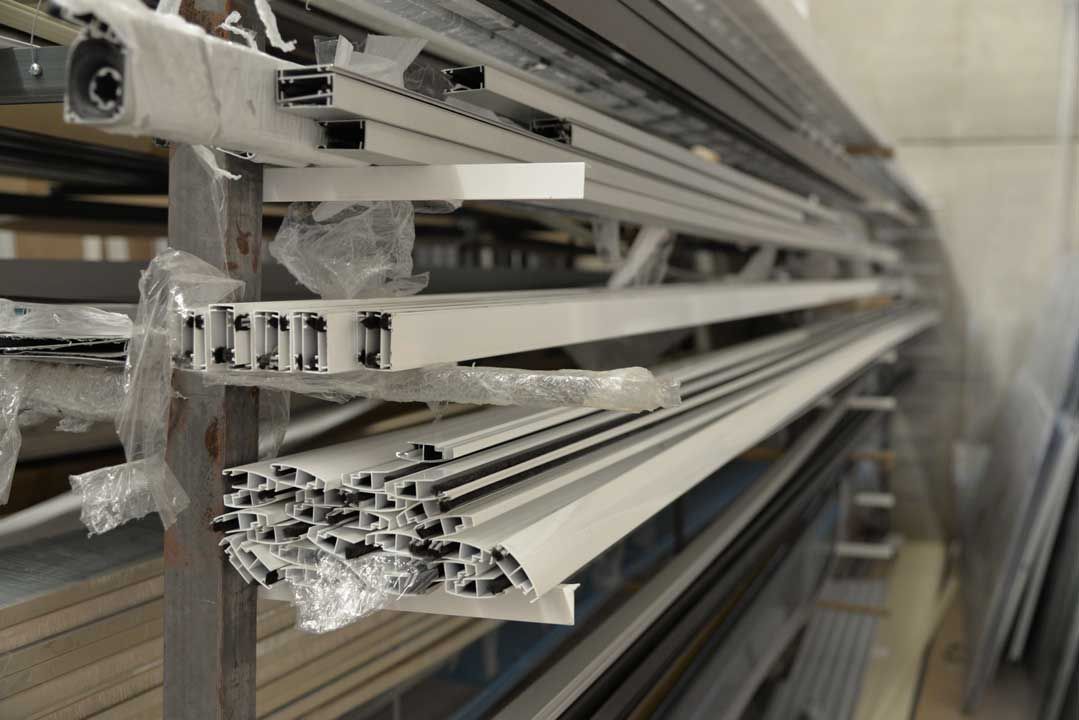 Un almacén lleno de muchos tubos de aluminio apilados uno encima del otro.