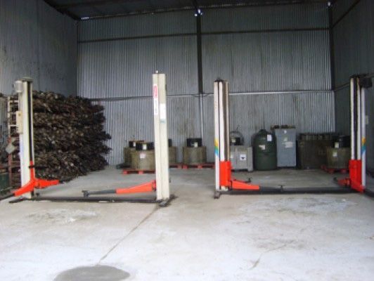 Un almacén con un montón de barriles y un par de ascensores.