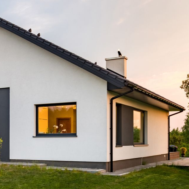 Maison blanche avec toit noir.