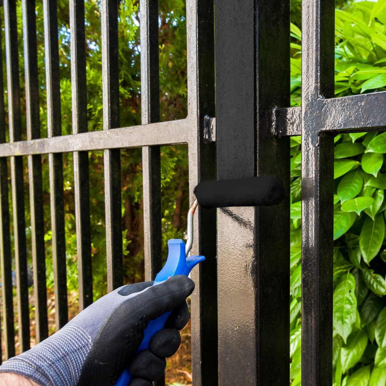 Peinture d'une porte en métal noir avec un rouleau.
