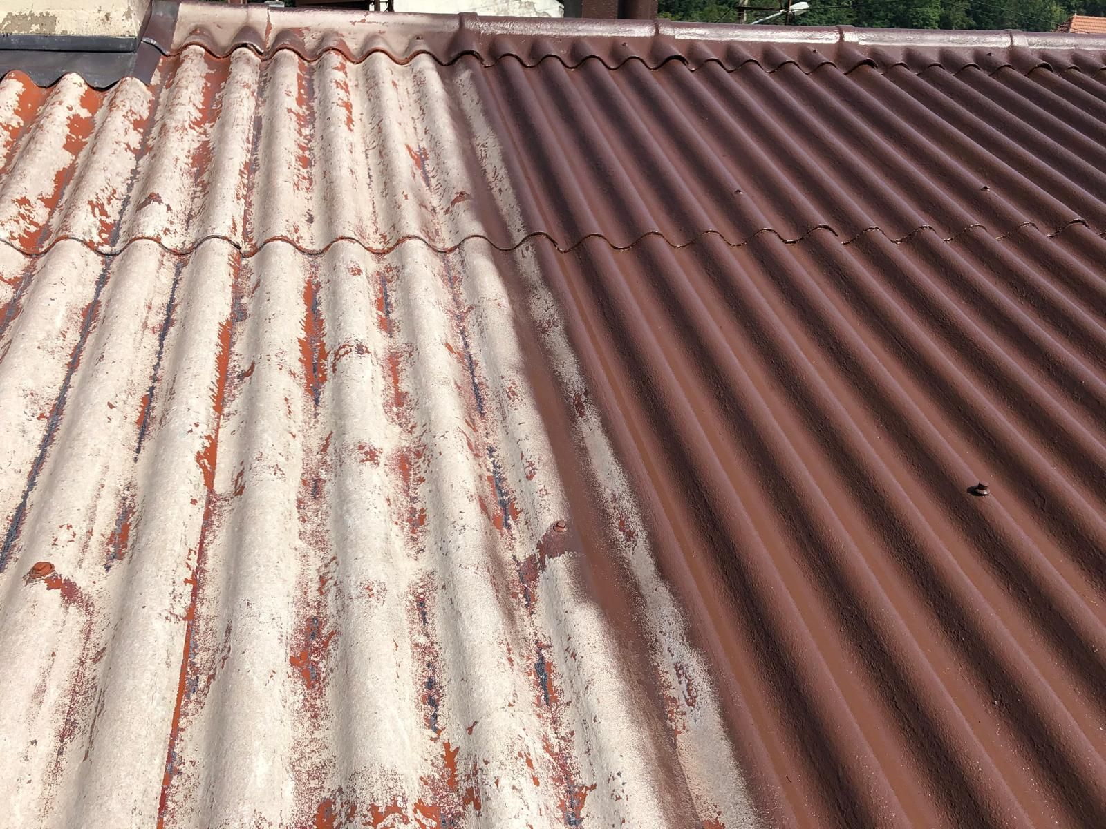 Toiture en tôle ondulée, moitié peinte en marron, moitié avec de la peinture blanche écaillée.