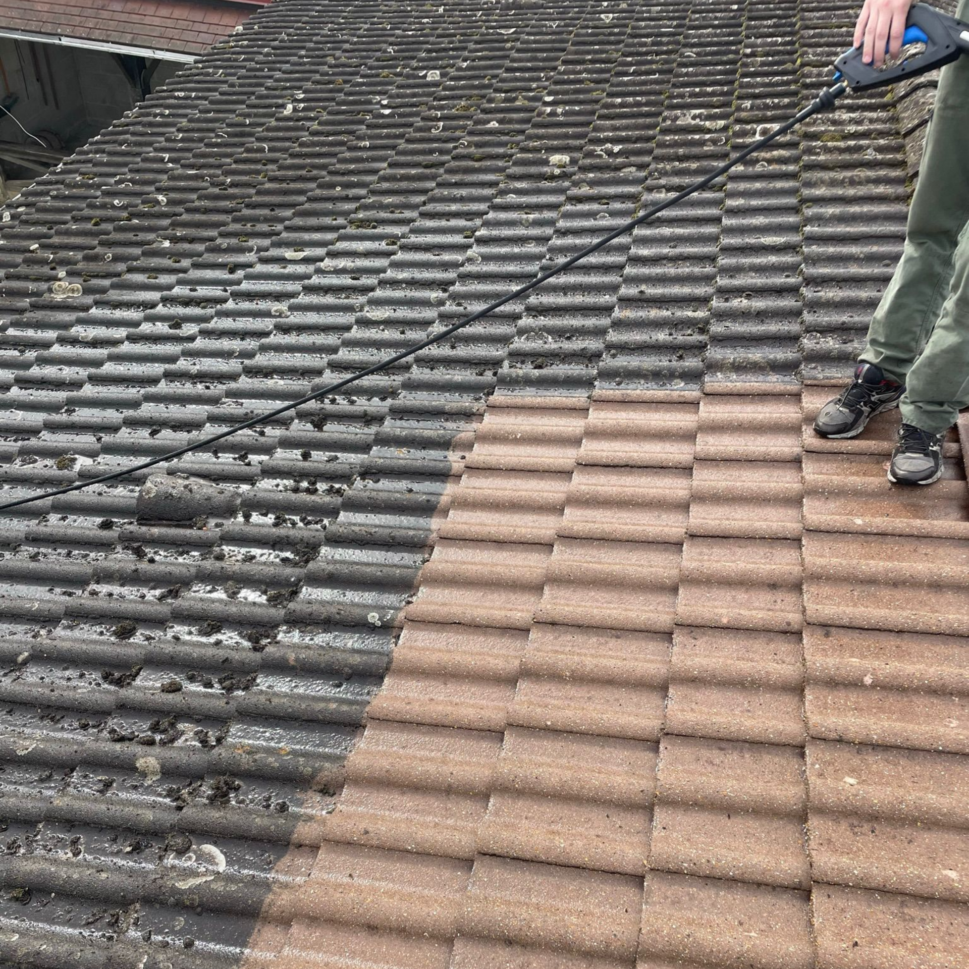 Nettoyage d'un toit en tuiles oranges.