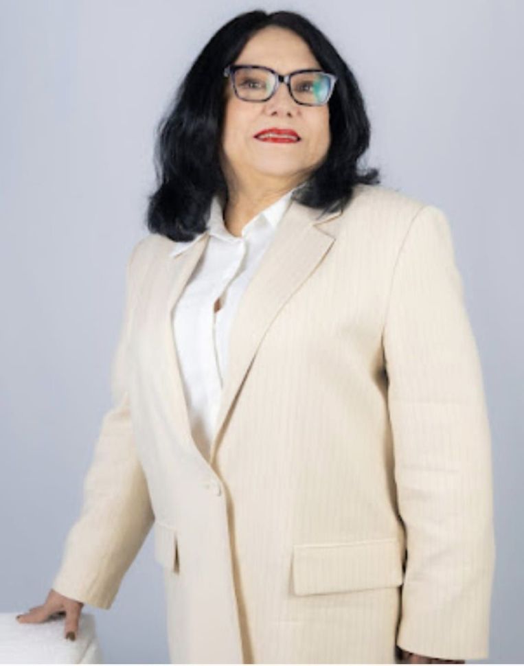 Una mujer con gafas y una chaqueta de traje color canela