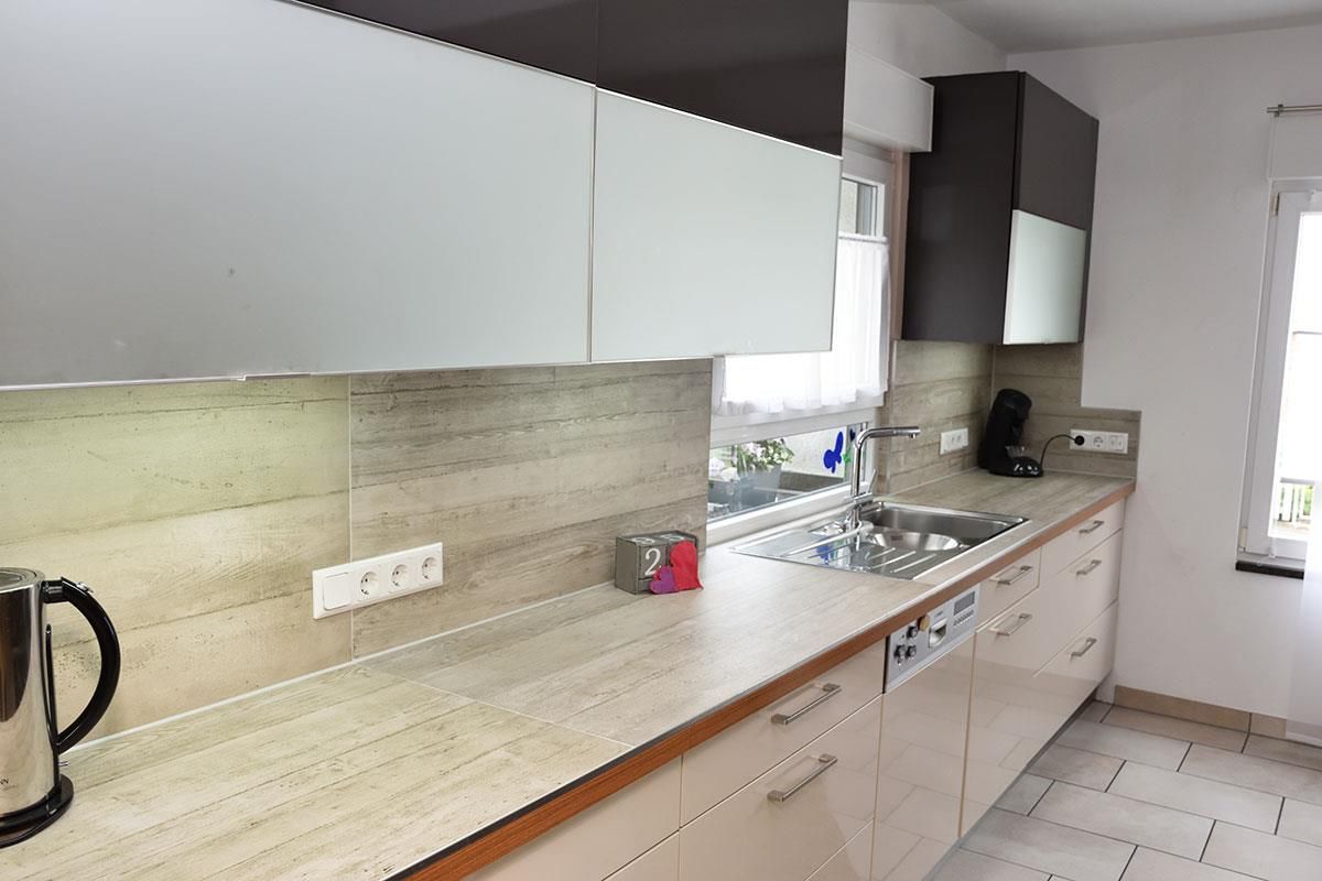 Eine Küche mit weißen Schränken und Geräten aus Edelstahl