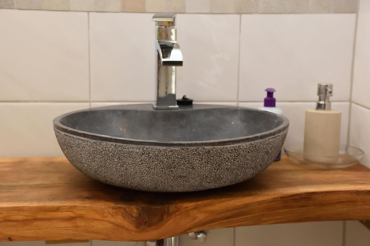 Ein Waschbecken im Badezimmer steht auf einer hölzernen Arbeitsplatte