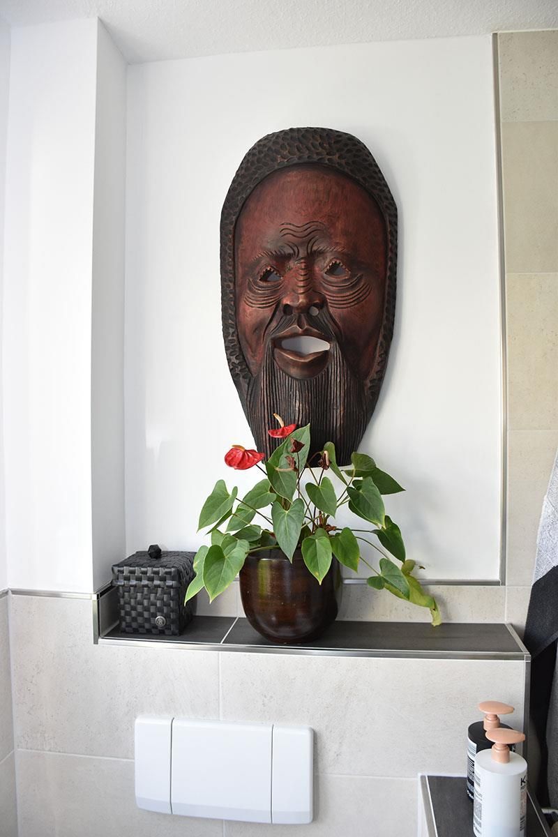 Eine Statue eines Mannes mit Bart steht über einer Topfpflanze