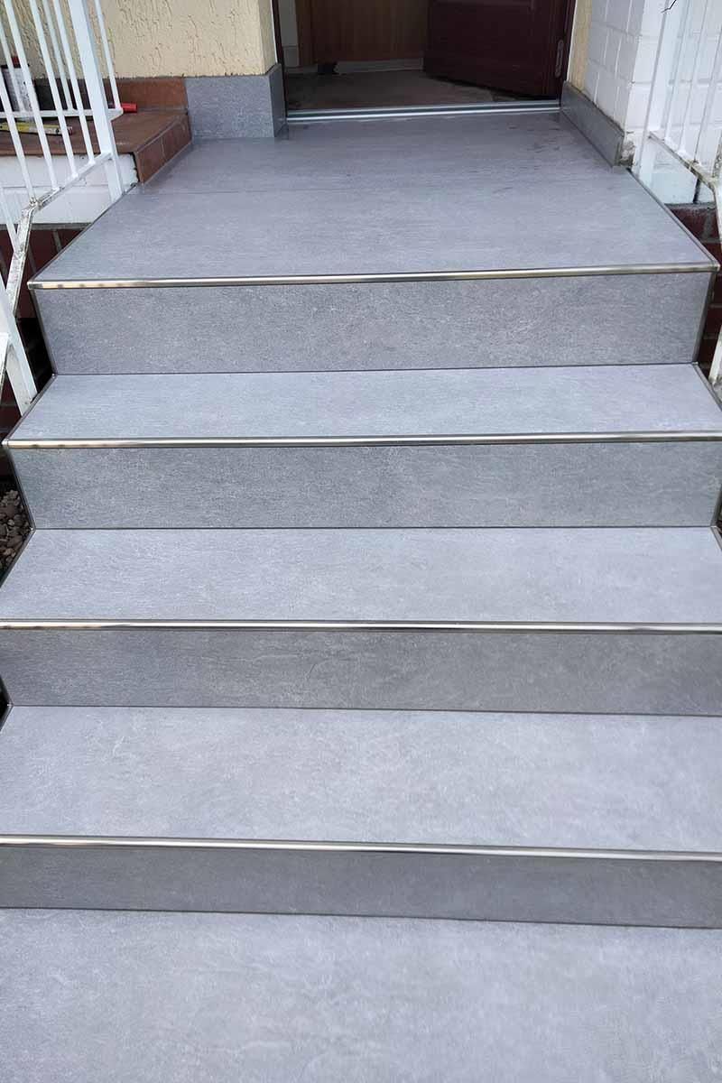 Eine Treppe mit einem Metallgeländer, die zu einer Tür führt.