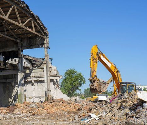 Una excavadora amarilla está demoliendo un edificio antiguo.