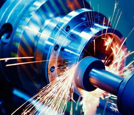 Una máquina está cortando un trozo de metal y salen chispas de él.