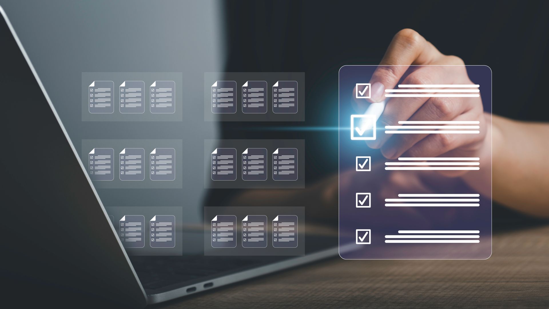 La main d'une personne coche une case sur une liste de contrôle numérique projetée sur un écran à côté d'un ordinateur portable.
