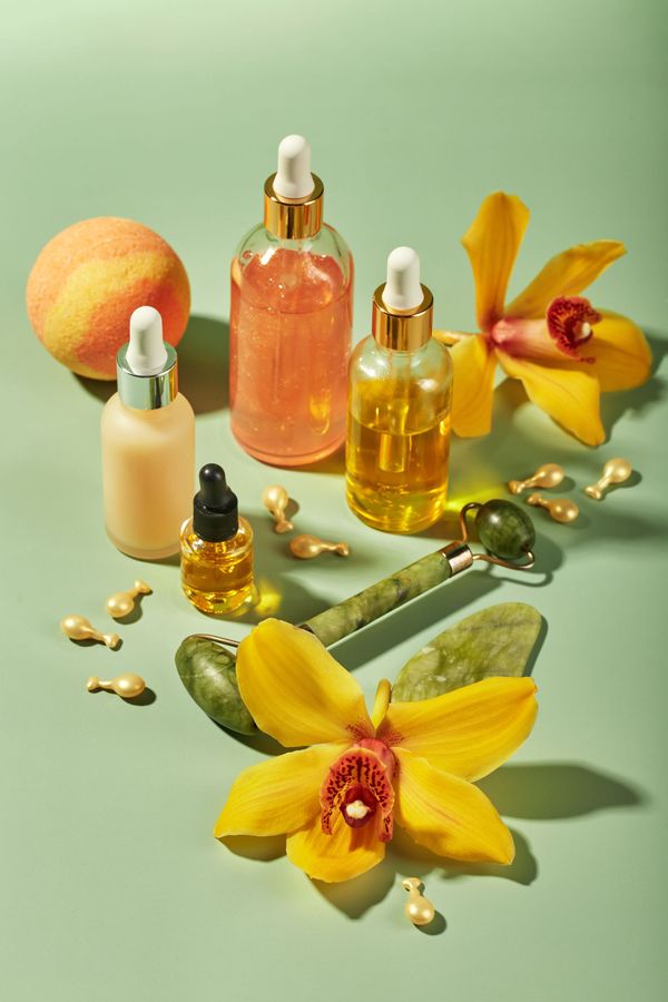 Des flacons compte-gouttes contenant des liquides avec des orchidées