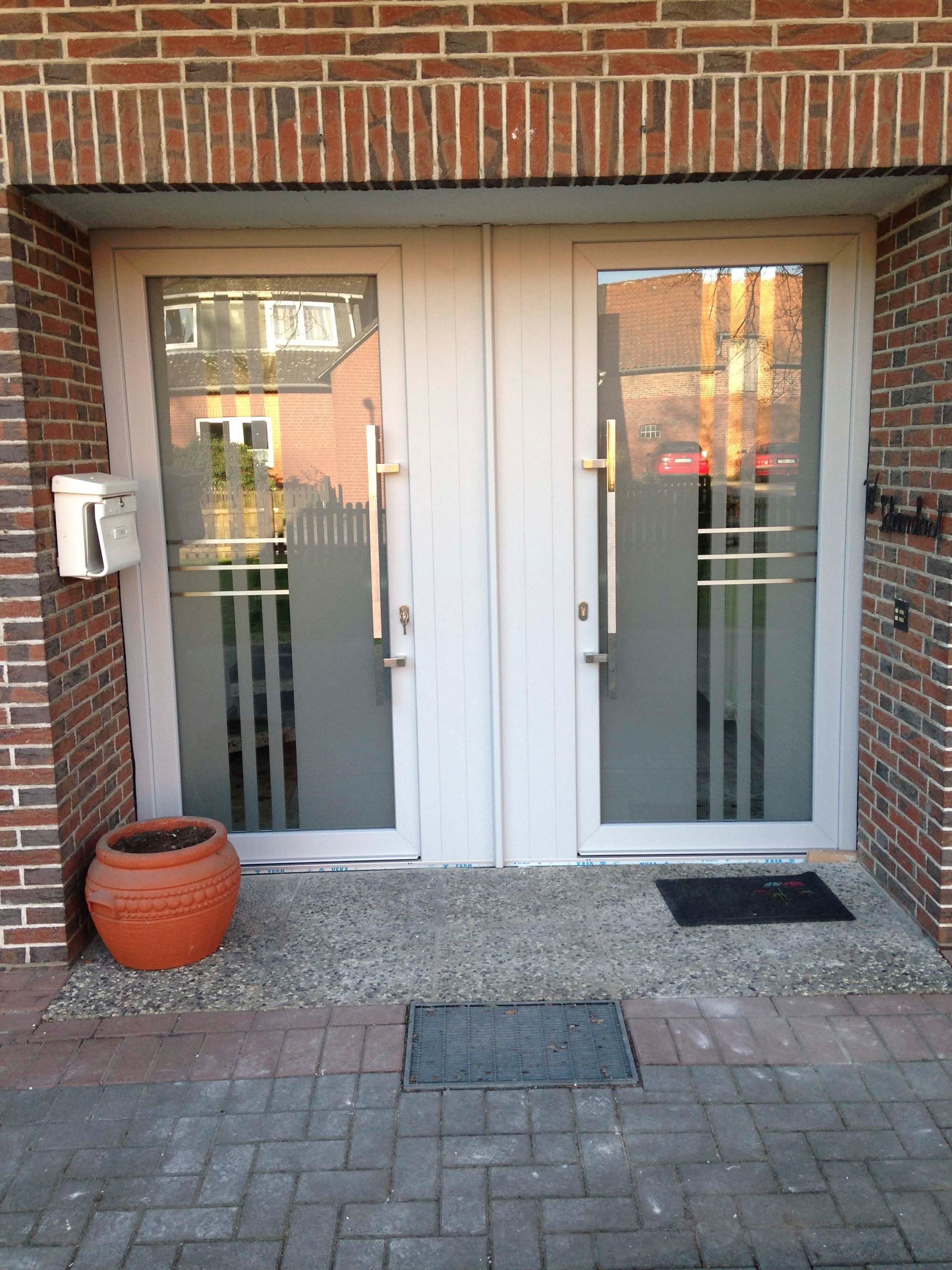 Ein Backsteingebäude mit einer weißen Tür und einem Briefkasten