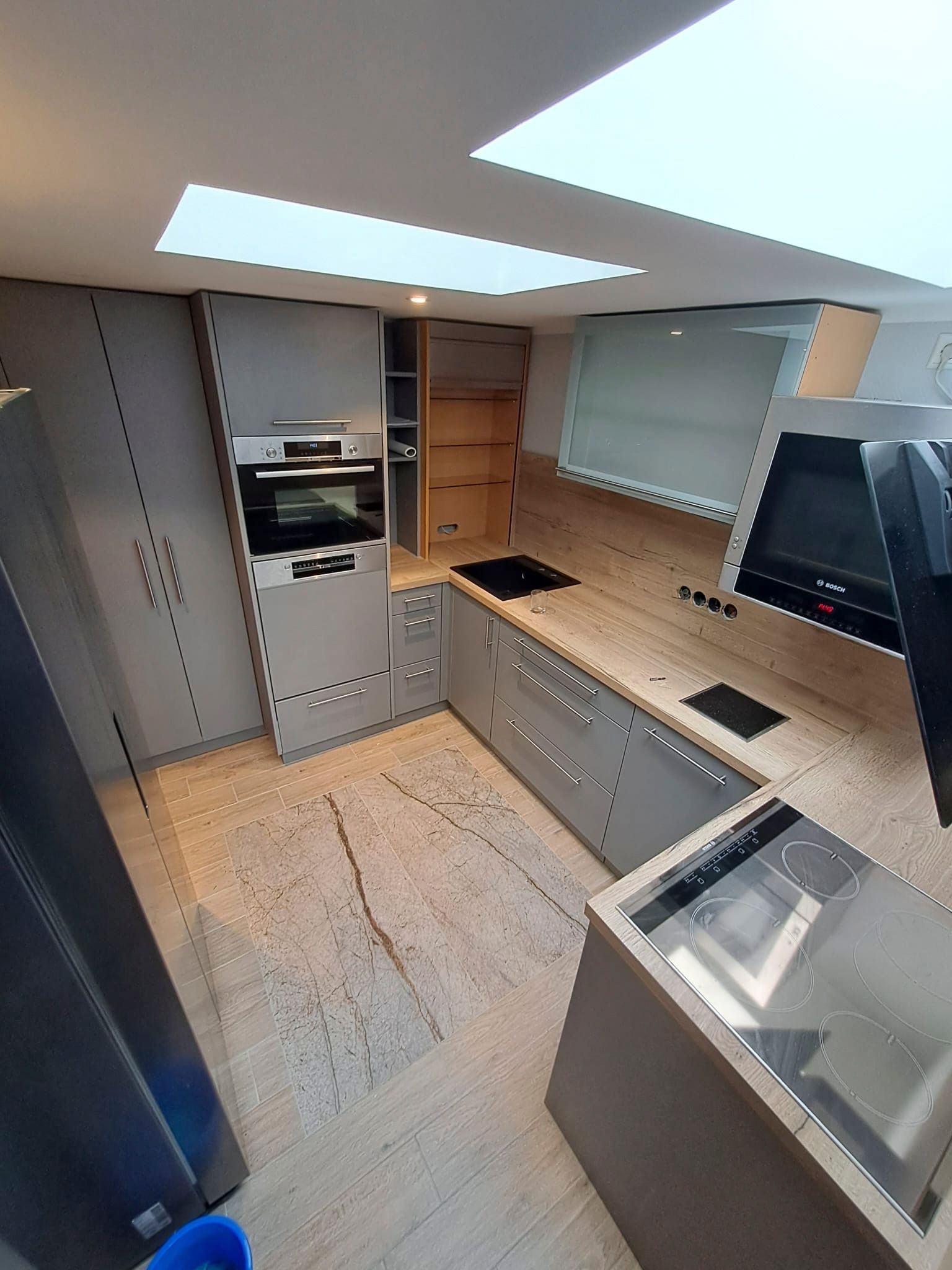 Eine Küche mit Geräten aus Edelstahl und Arbeitsplatten aus Granit.