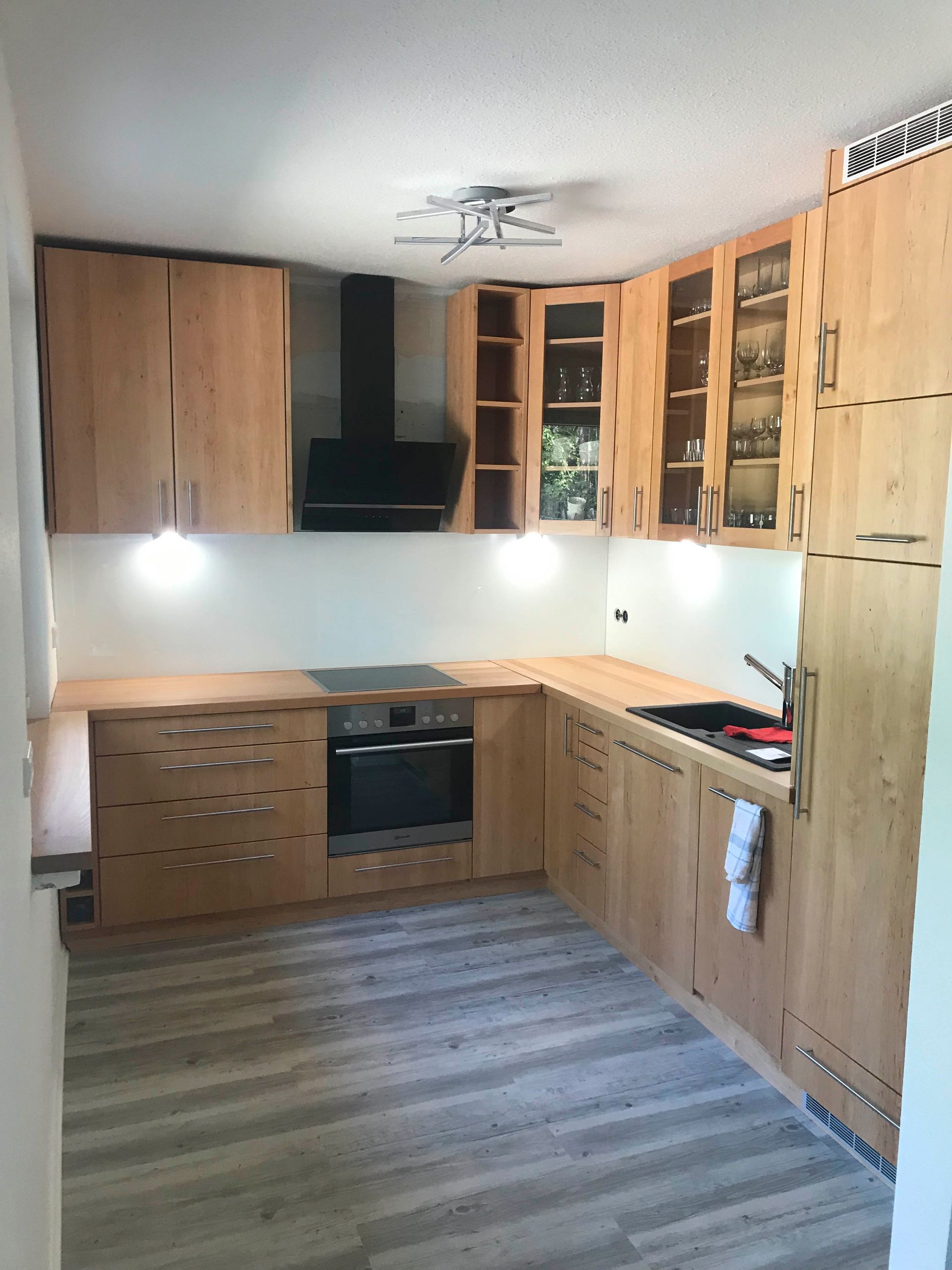 Eine Küche mit Holzschränken und einem Herd mit Backofen