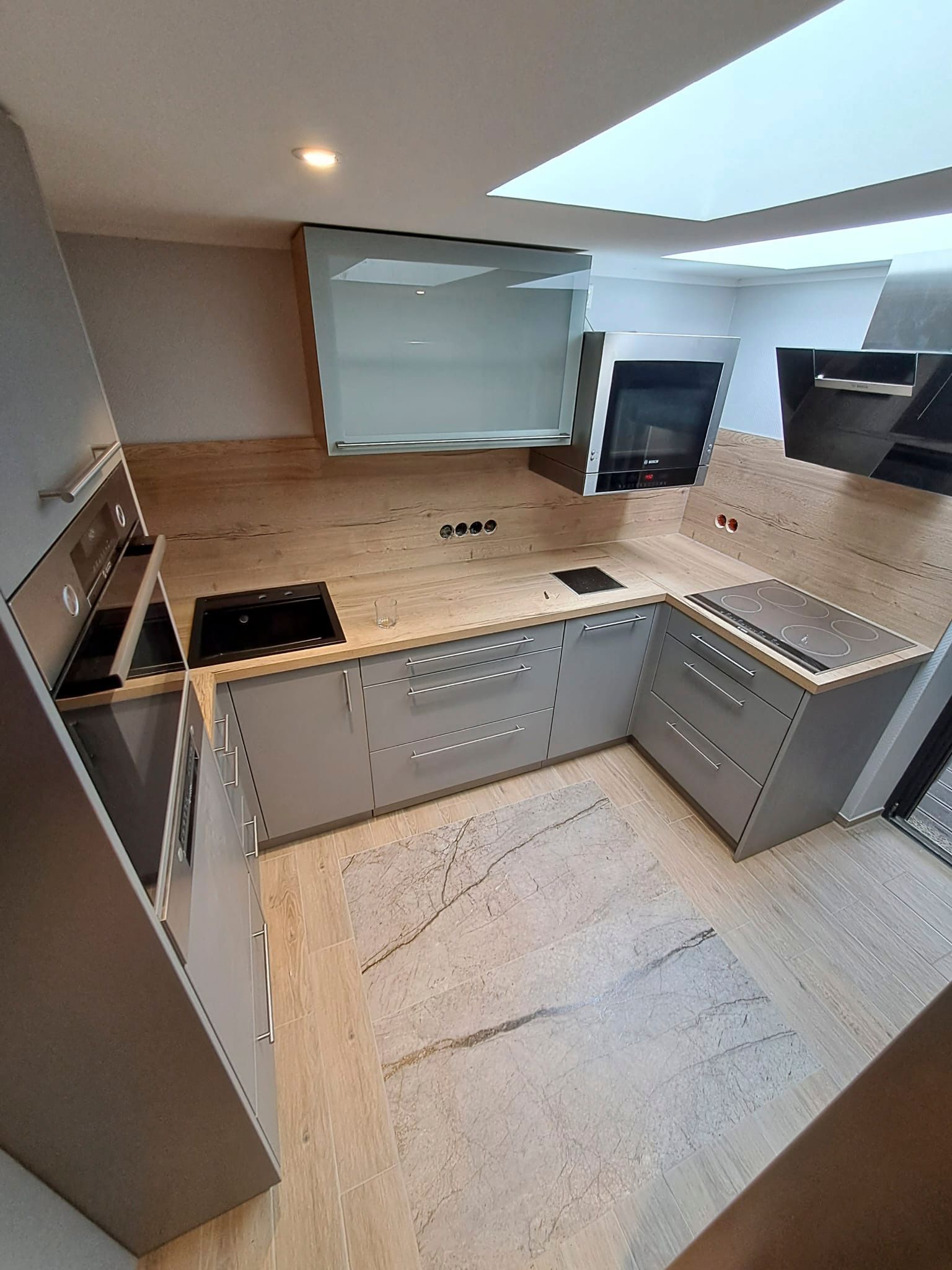 Eine Küche mit Herd, Spüle und Backofen.