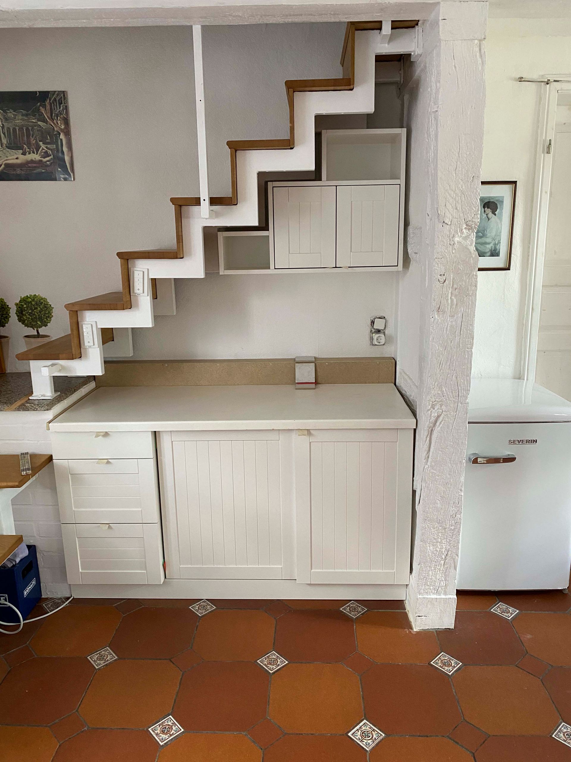 Eine Küche mit einer Treppe, die in den zweiten Stock führt.