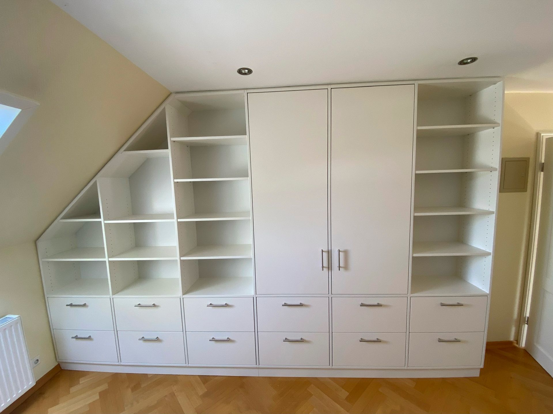 Ein Raum mit vielen weißen Regalen und Schubladen