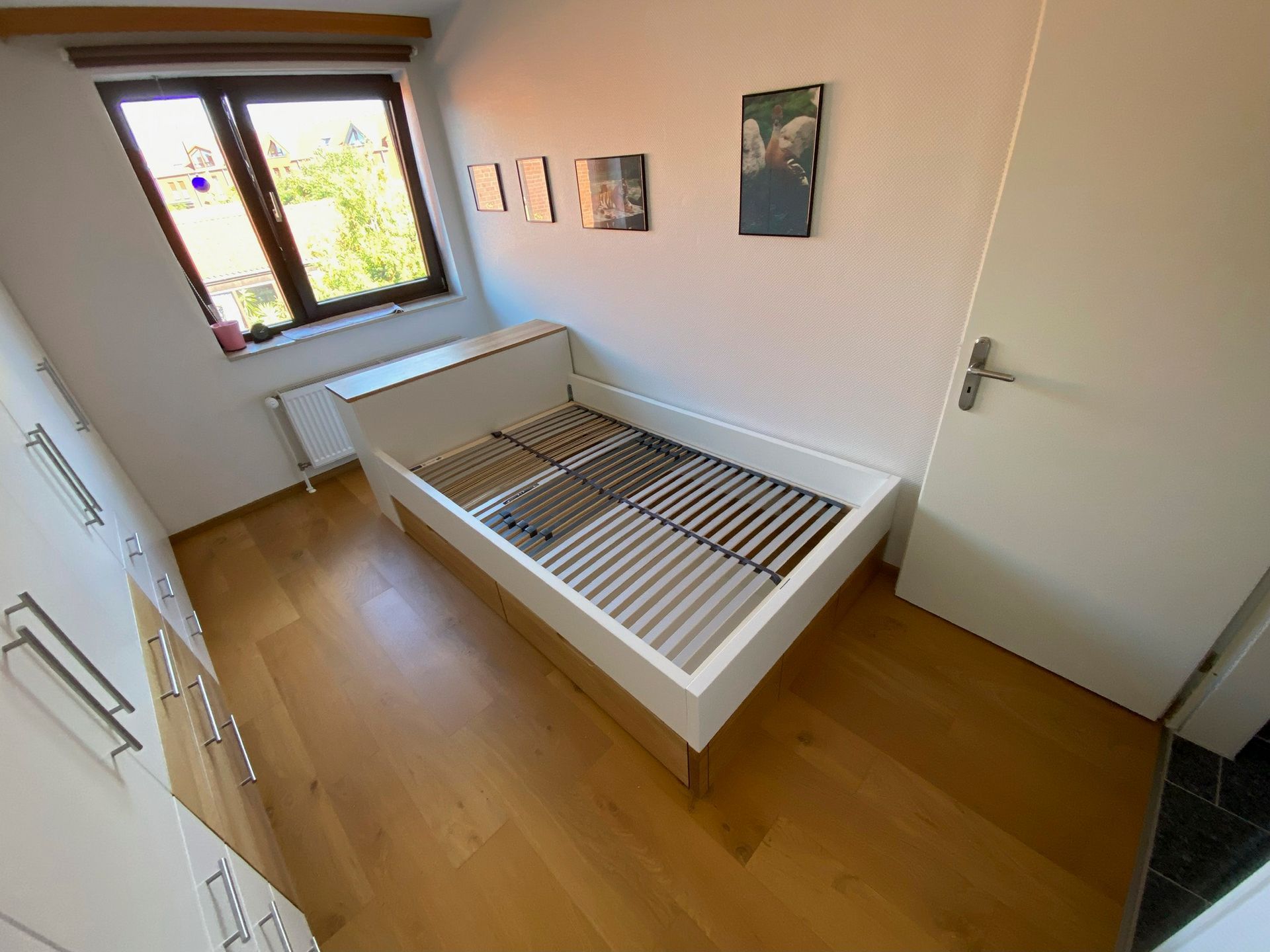 Ein Schlafzimmer mit einem Bett, einem Fenster und einer Tür.