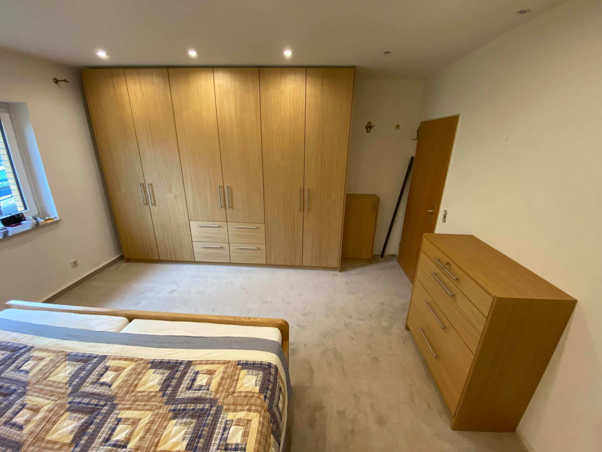 Ein Schlafzimmer mit Bett, Kommode und Kleiderschrank.