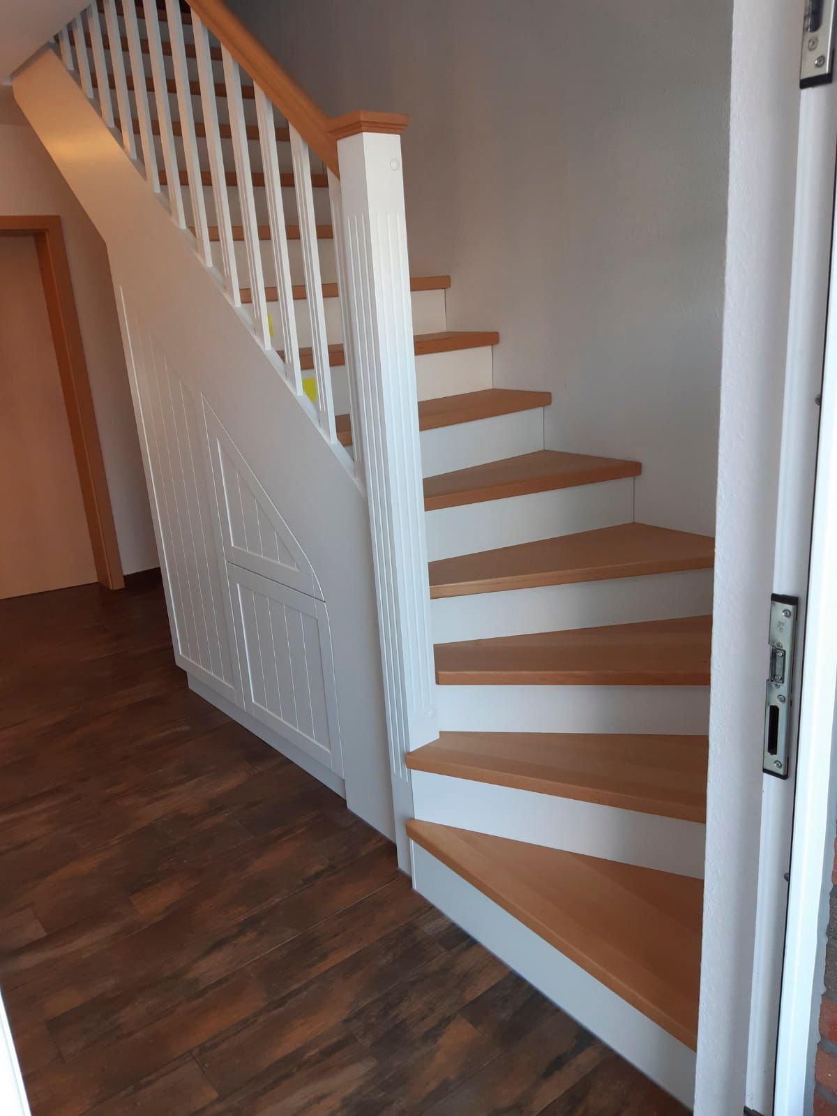 Eine Treppe mit Holzstufen und weißem Geländer