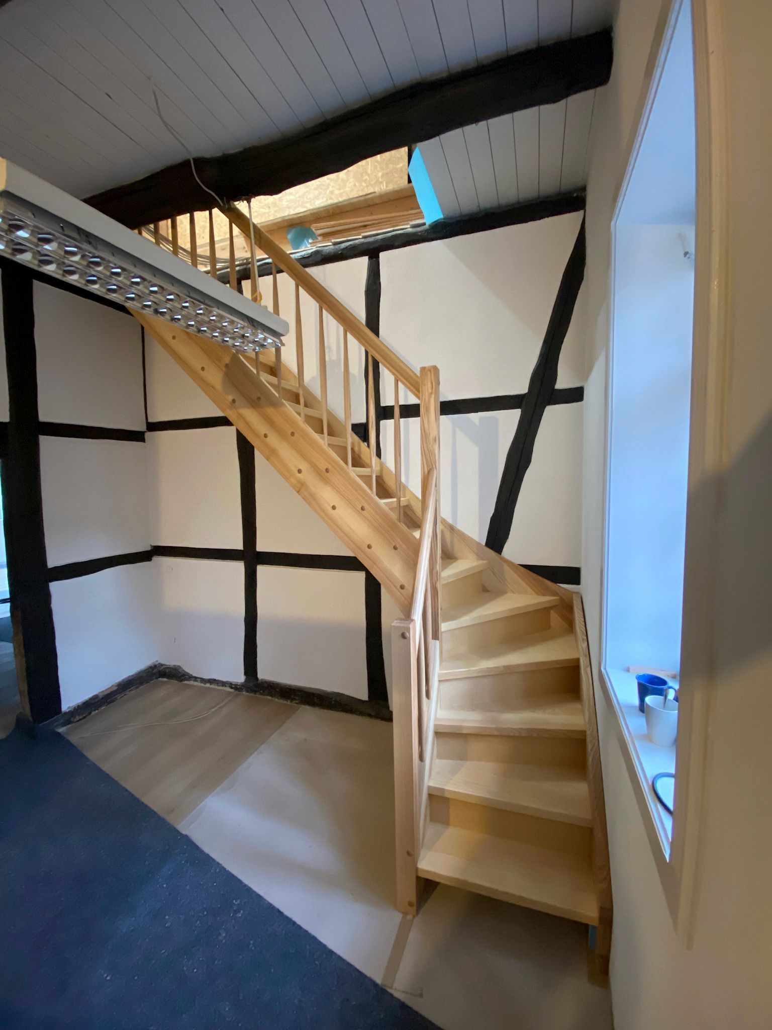 Eine Holztreppe in einem Raum mit Fenster