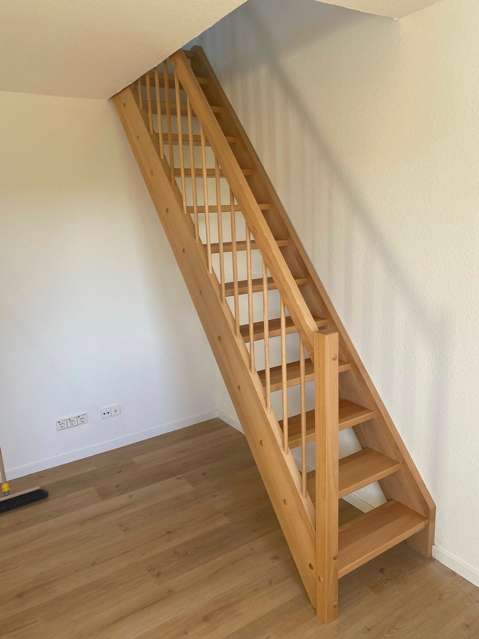 Eine Holztreppe in einem Raum mit Holzboden.