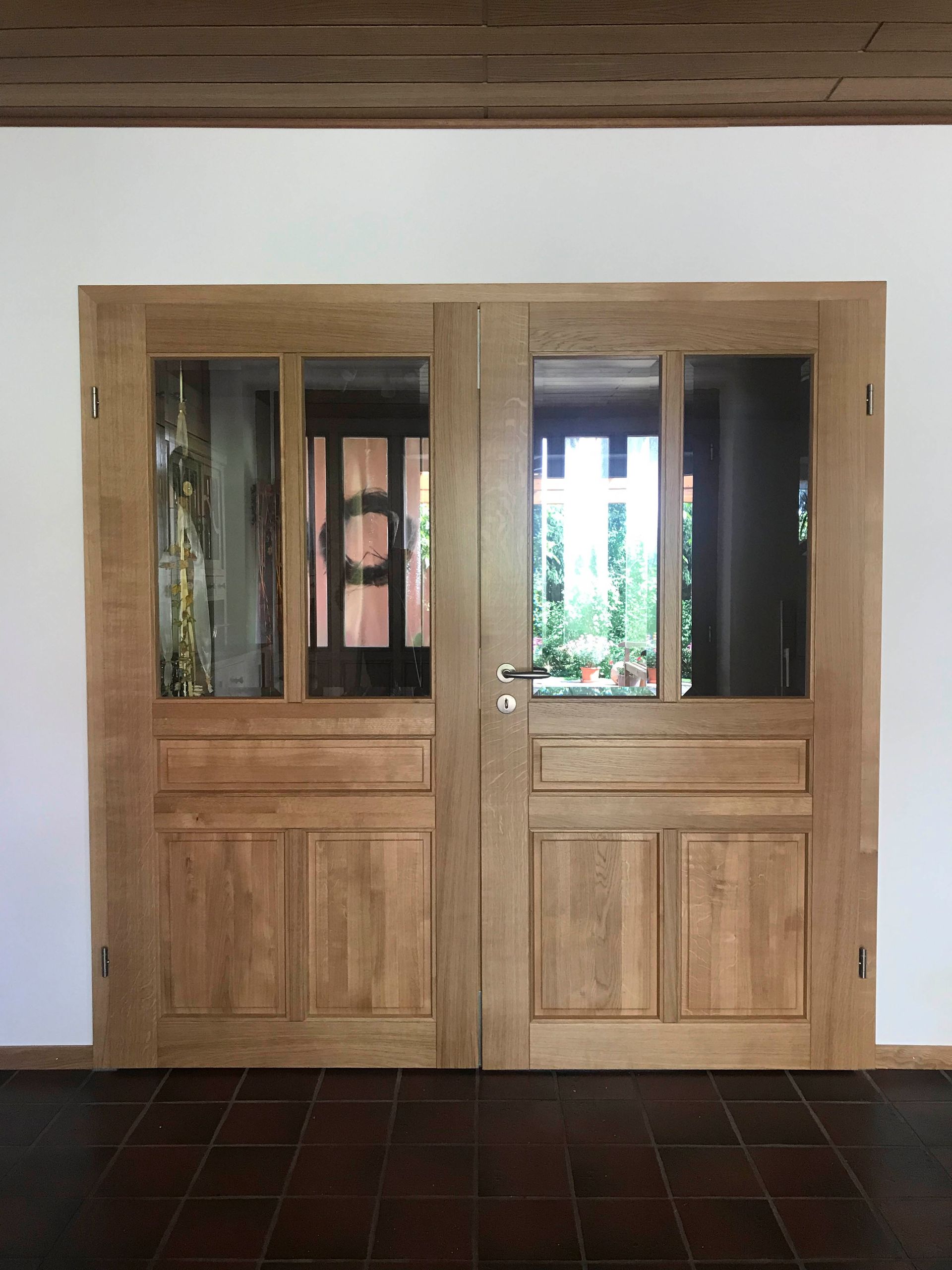 Ein Paar Holztüren mit Glasfenstern in einem Raum.